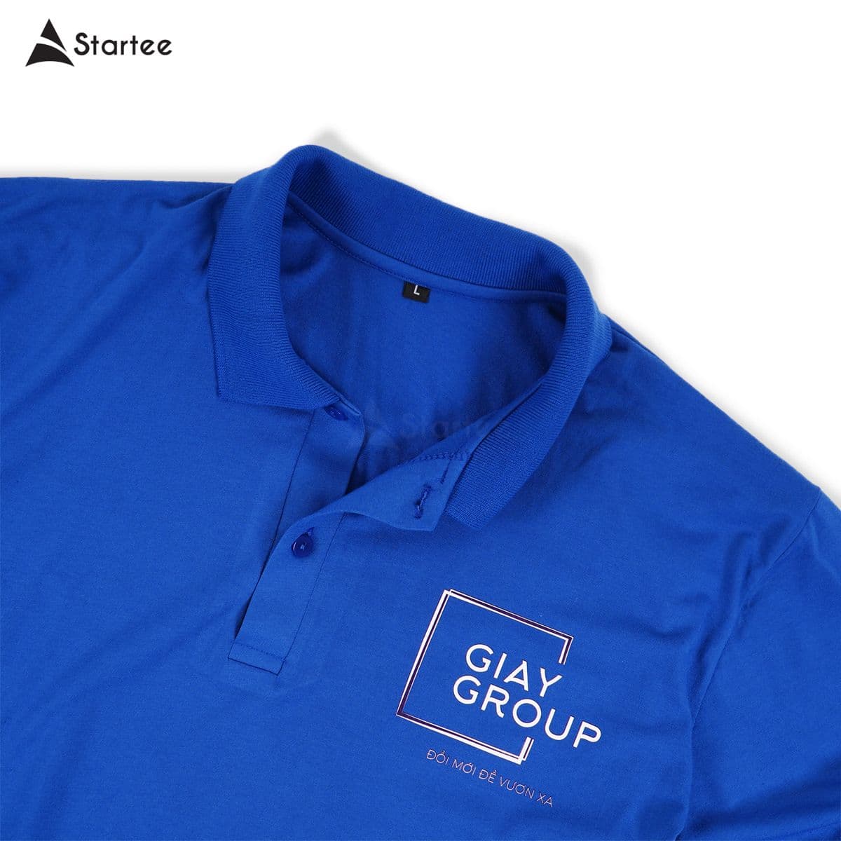 Cận cảnh logo in trắng trên ngực áo polo xanh dương